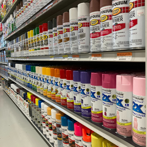 Shelves filled with colorful spray paint cans, neatly organized by type and color. The image conveys a sense of variety and creativity.
