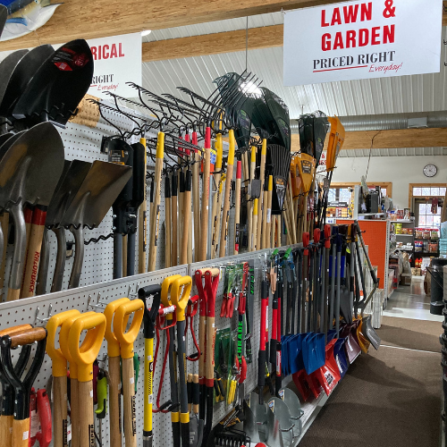 Wide variety of gardening tools displayed on a store shelf under a 